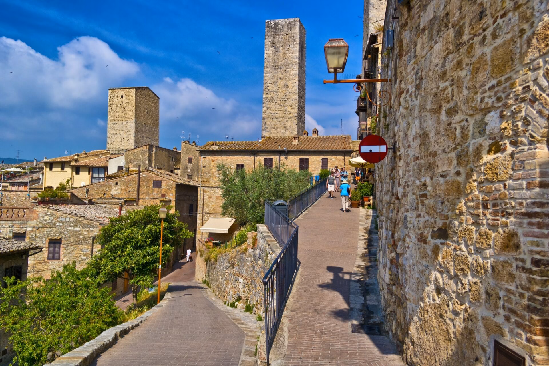 Street in the historic centre of San Gimignano with tourists and medieval towers