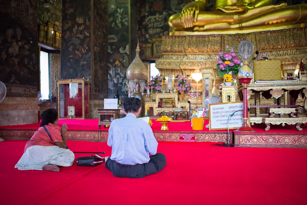 Inside a Bangkok Buddhist temple — interior with murals and Buddha statue