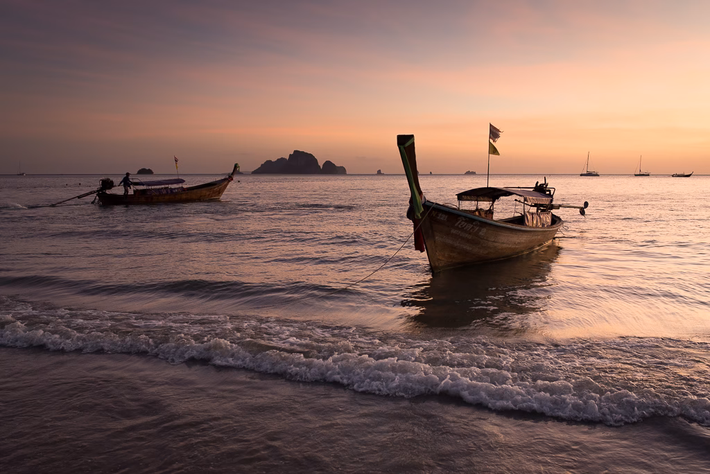 Thai longtail boats on Railay Beach at sunset.
