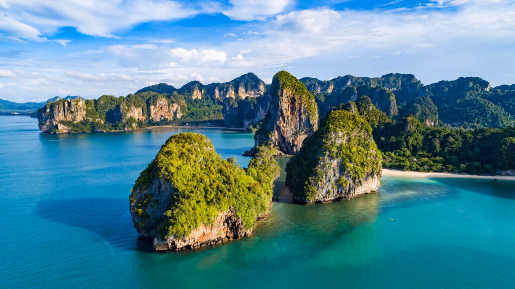 Railay Beach, Krabi, Thailand: view of the beach with vegetation-covered limestone formations.