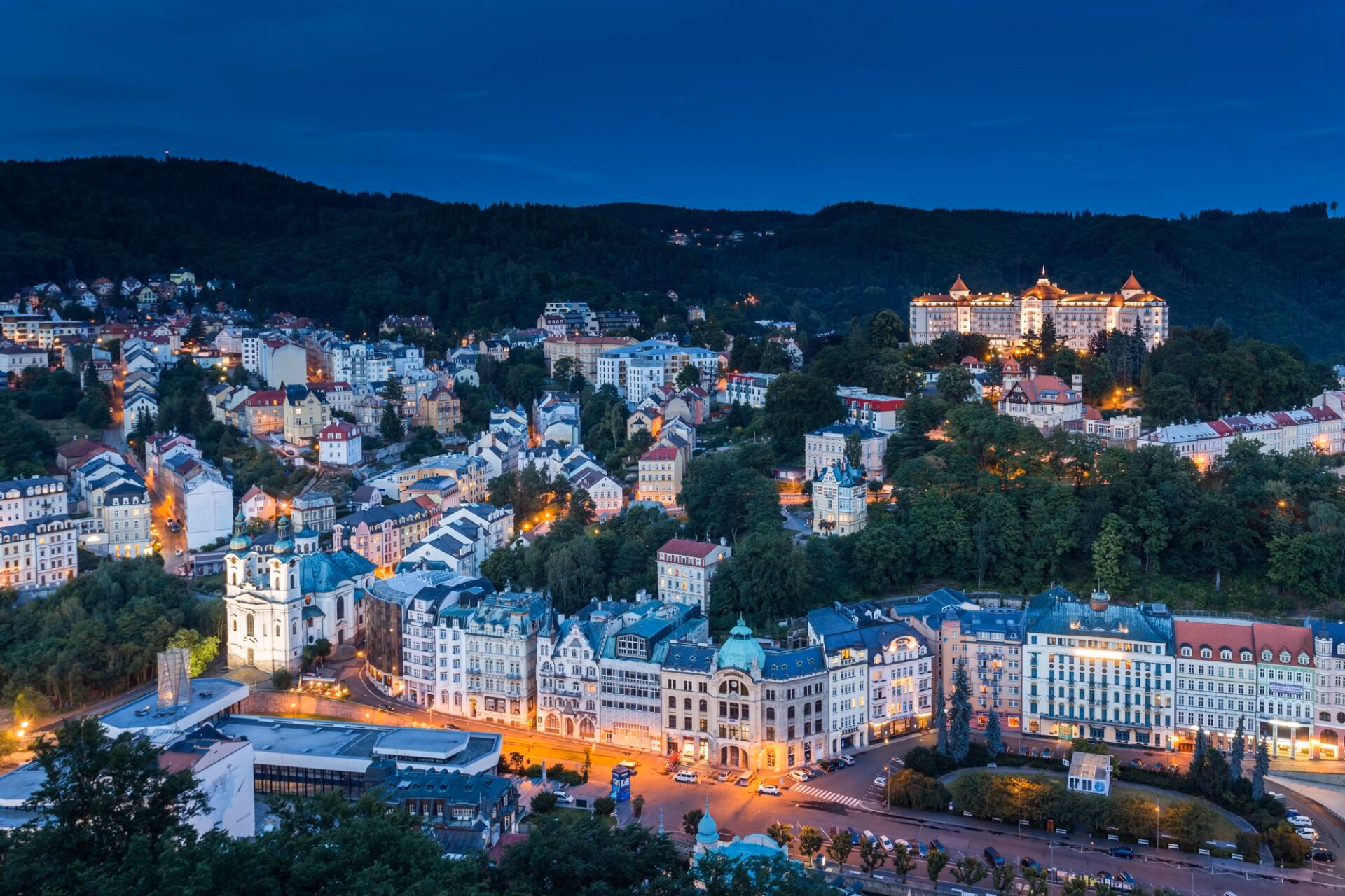 Karlovy Vary panorama at dusk with the illuminated Hotel Imperial above the town
