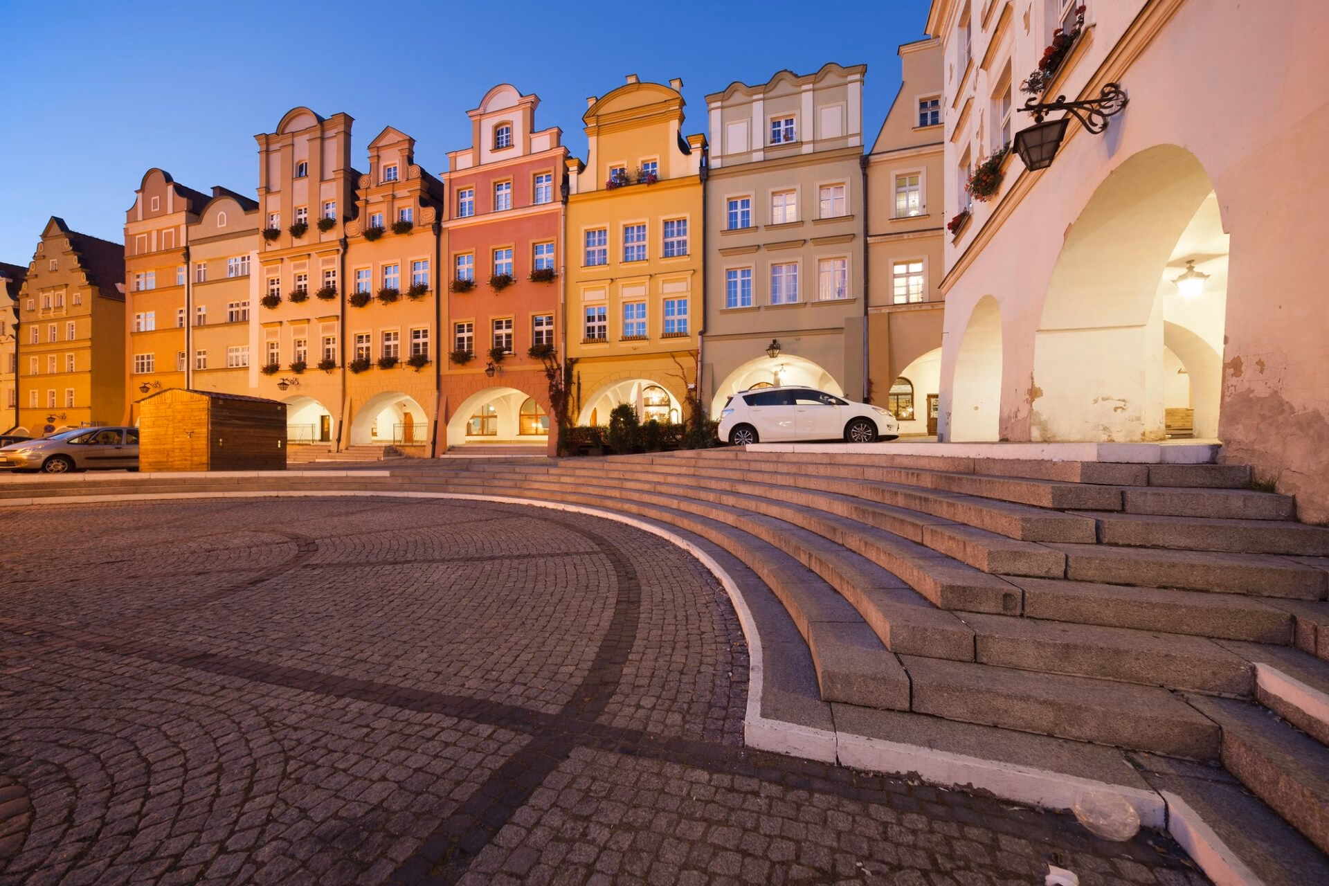 Town Hall Square (Plac Ratuszowy) in Jelenia Góra at night with illuminated arcaded houses