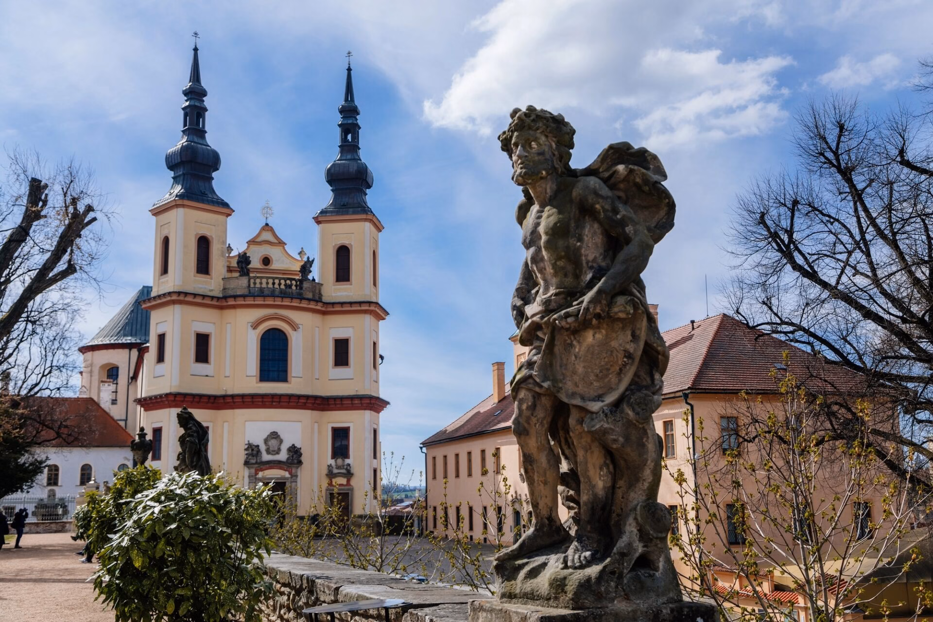 Piarist Church of the Finding of the Holy Cross in Litomyšl with a baroque statue in the foreground