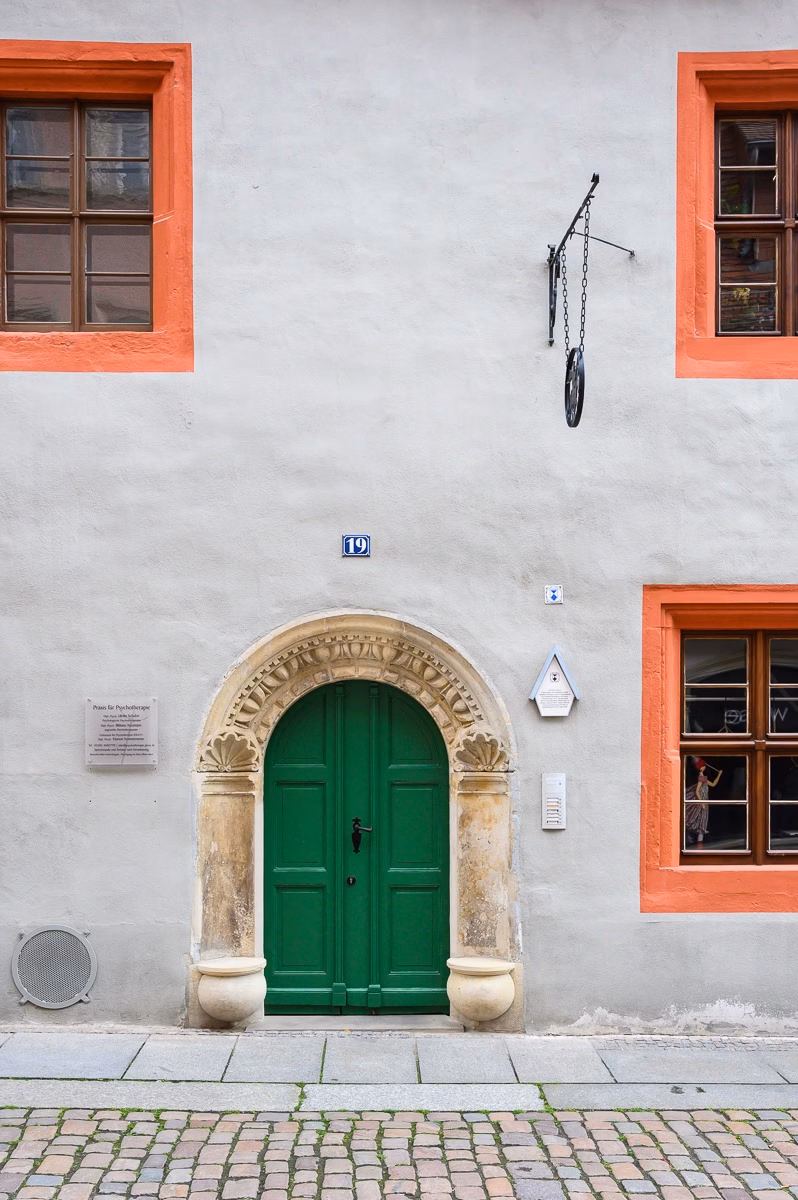 Preserved stone portal with green doors on a Renaissance house in Pirna