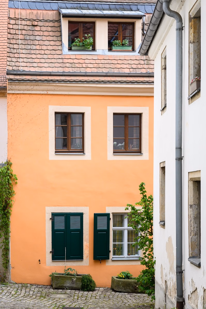 Orange façade of a historic house with green shutters in Pirna