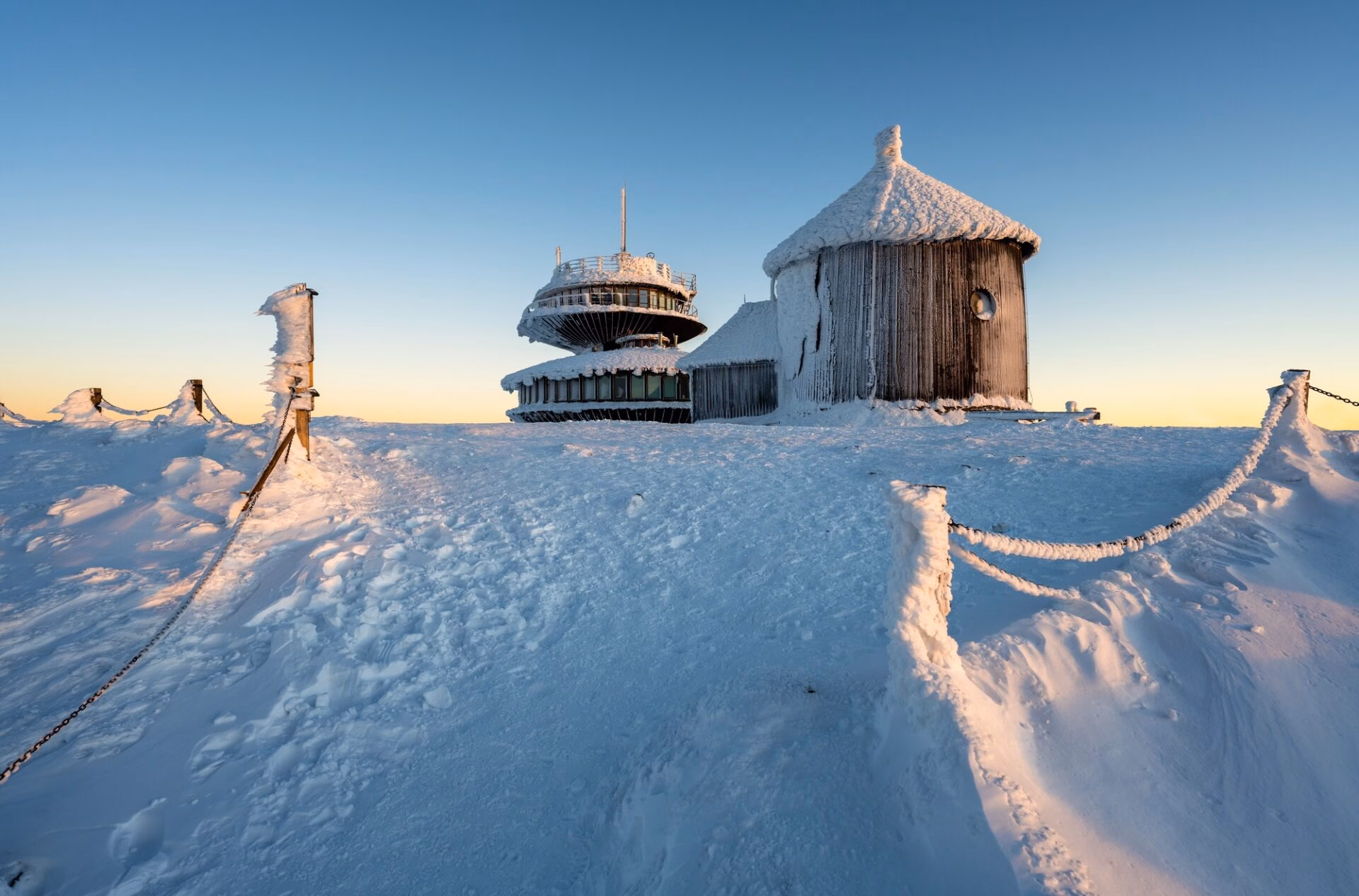 Snow-covered mountain hut and ridge views near Karpacz