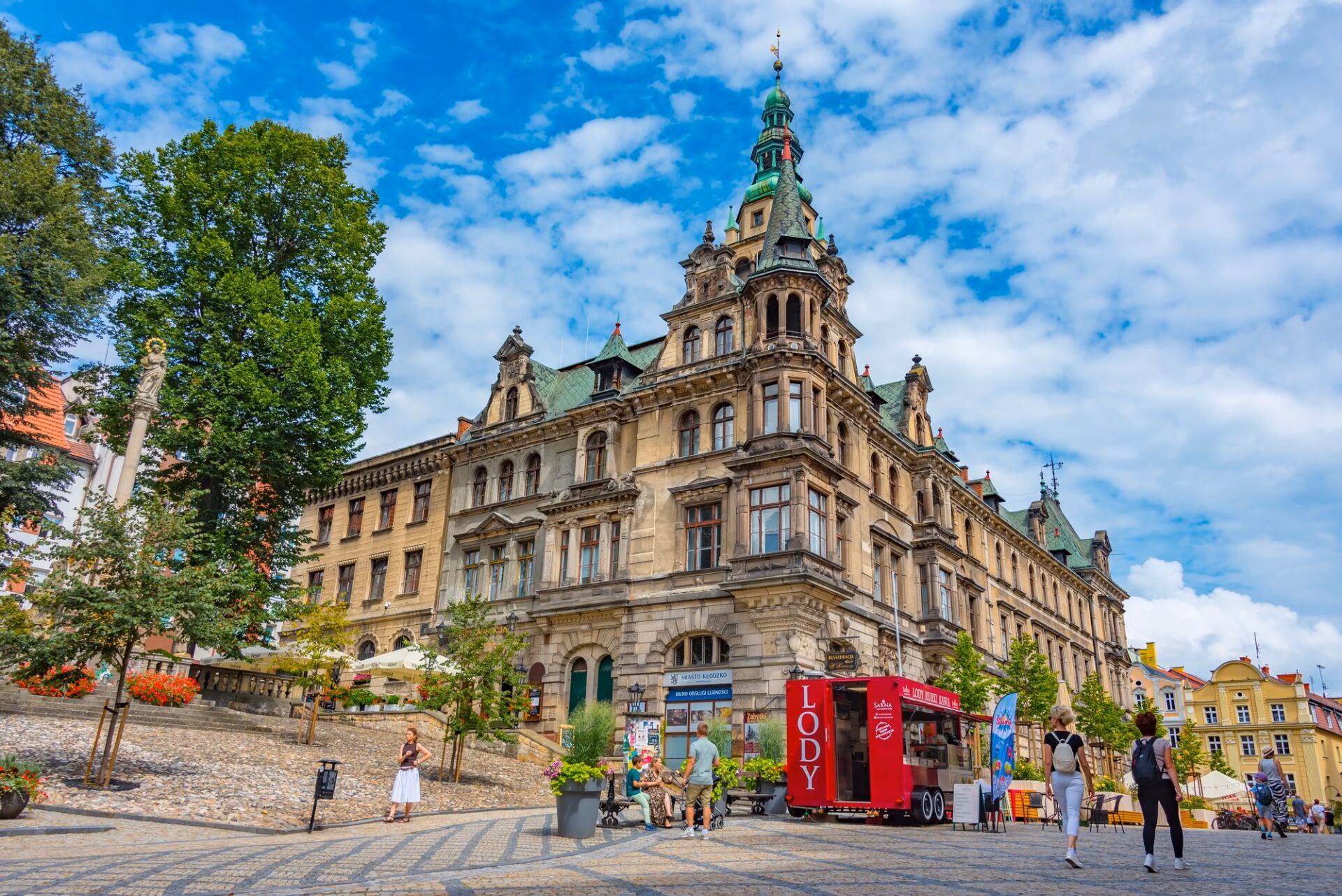 Sunny market square in Kłodzko with the town hall and an ice-cream stall