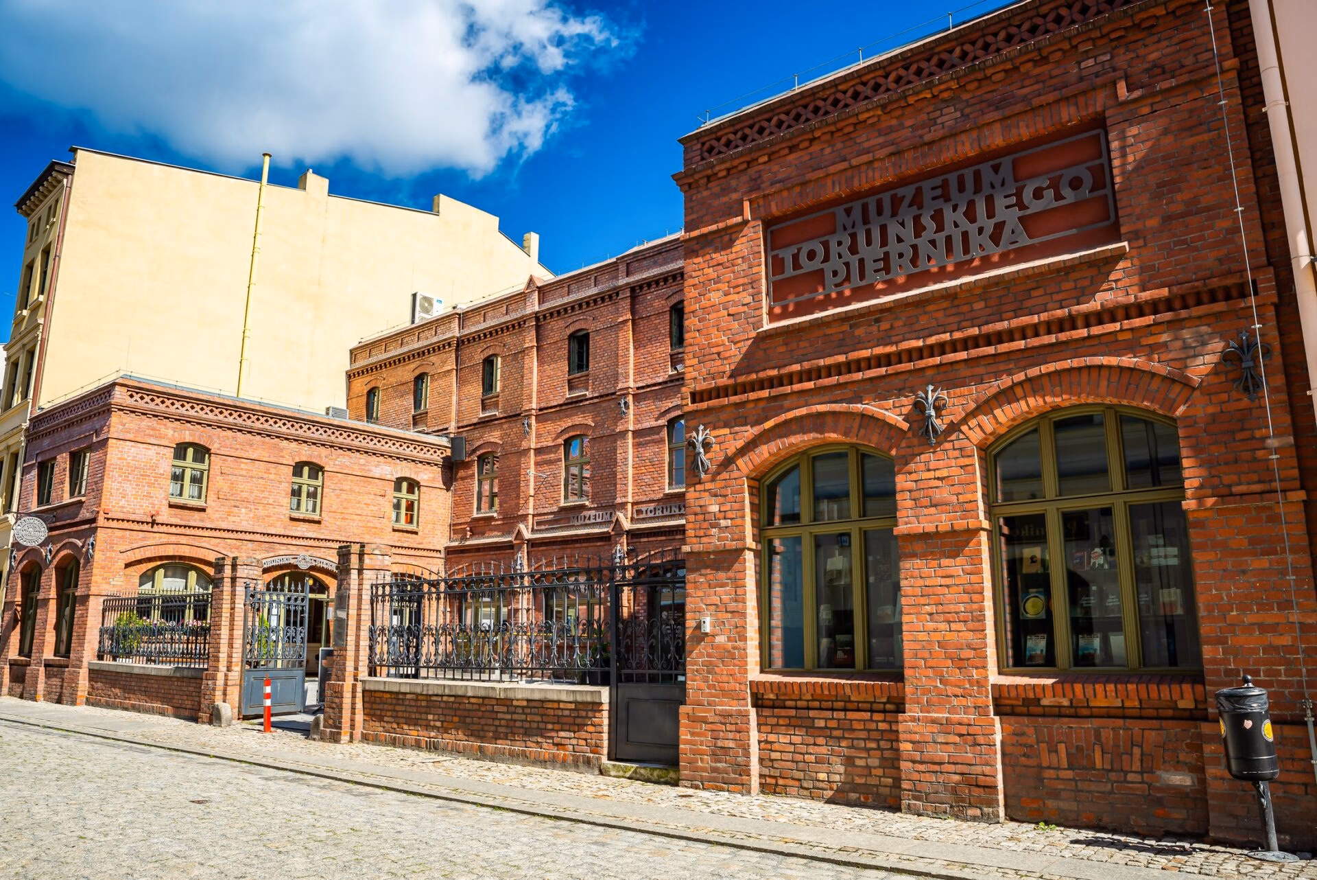 Brick building of the Toruń Gingerbread Museum with a sign on the facade