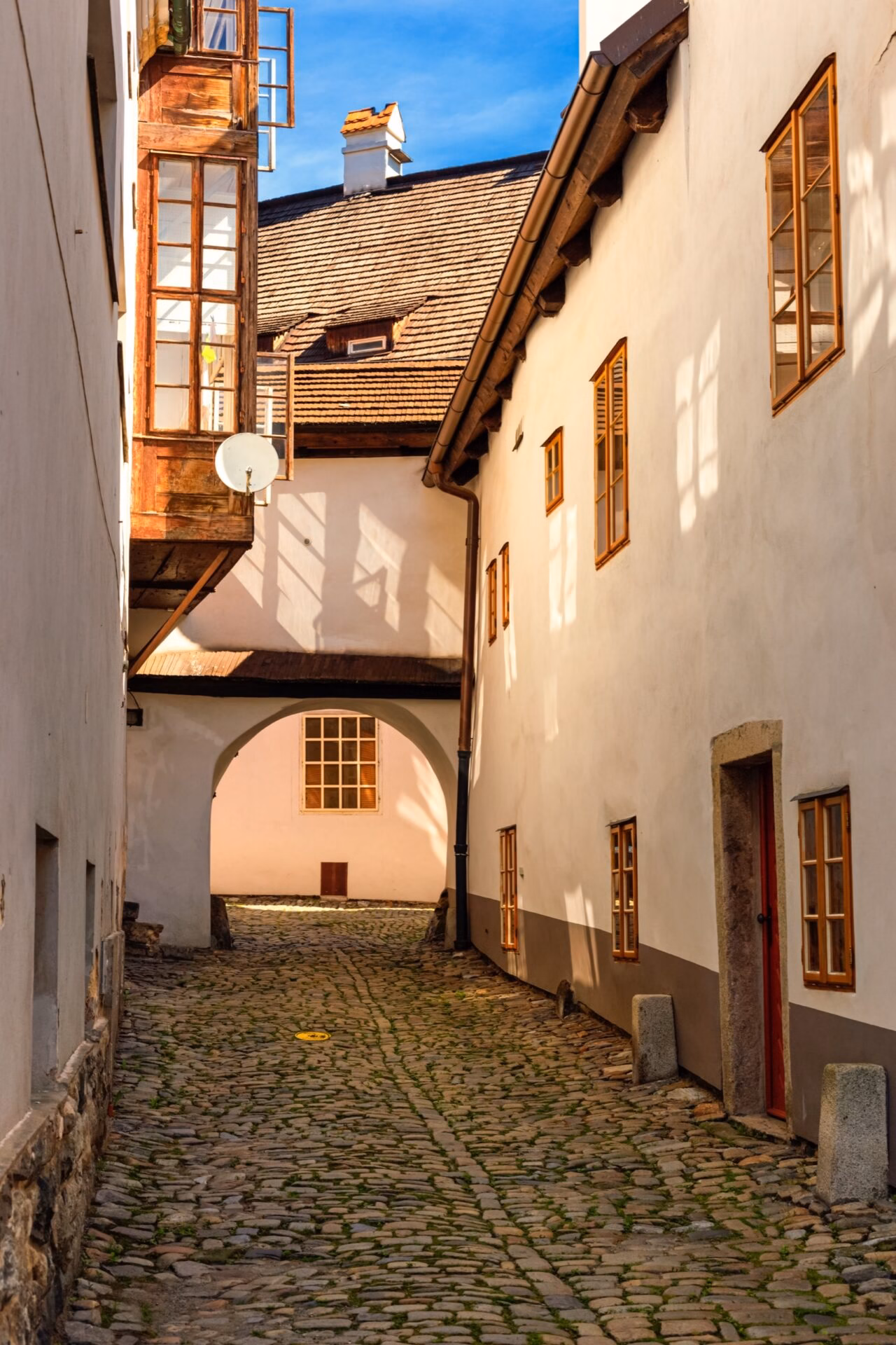 Narrow cobbled lane with an archway in the historic centre of Cesky Krumlov