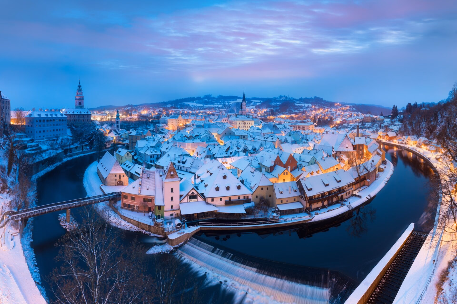 Winter panorama of Cesky Krumlov during blue hour with the weir on the Vltava