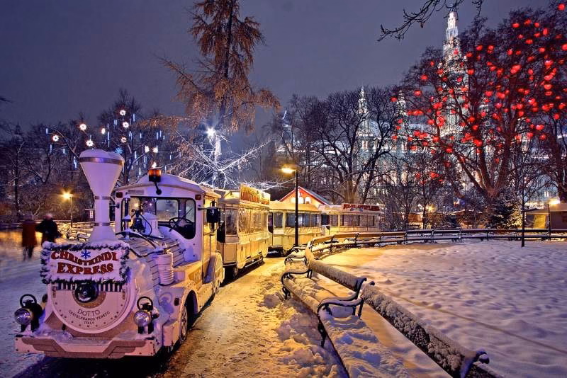 Vienna Christmas market in the snow near City Hall, with a children's train