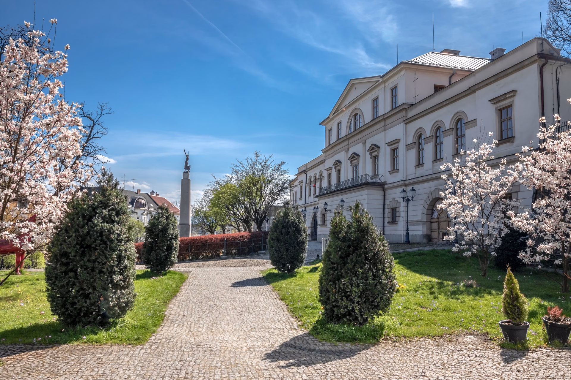 The neoclassical Zamek Cieszyn, a former Habsburg hunting lodge, with blooming magnolias