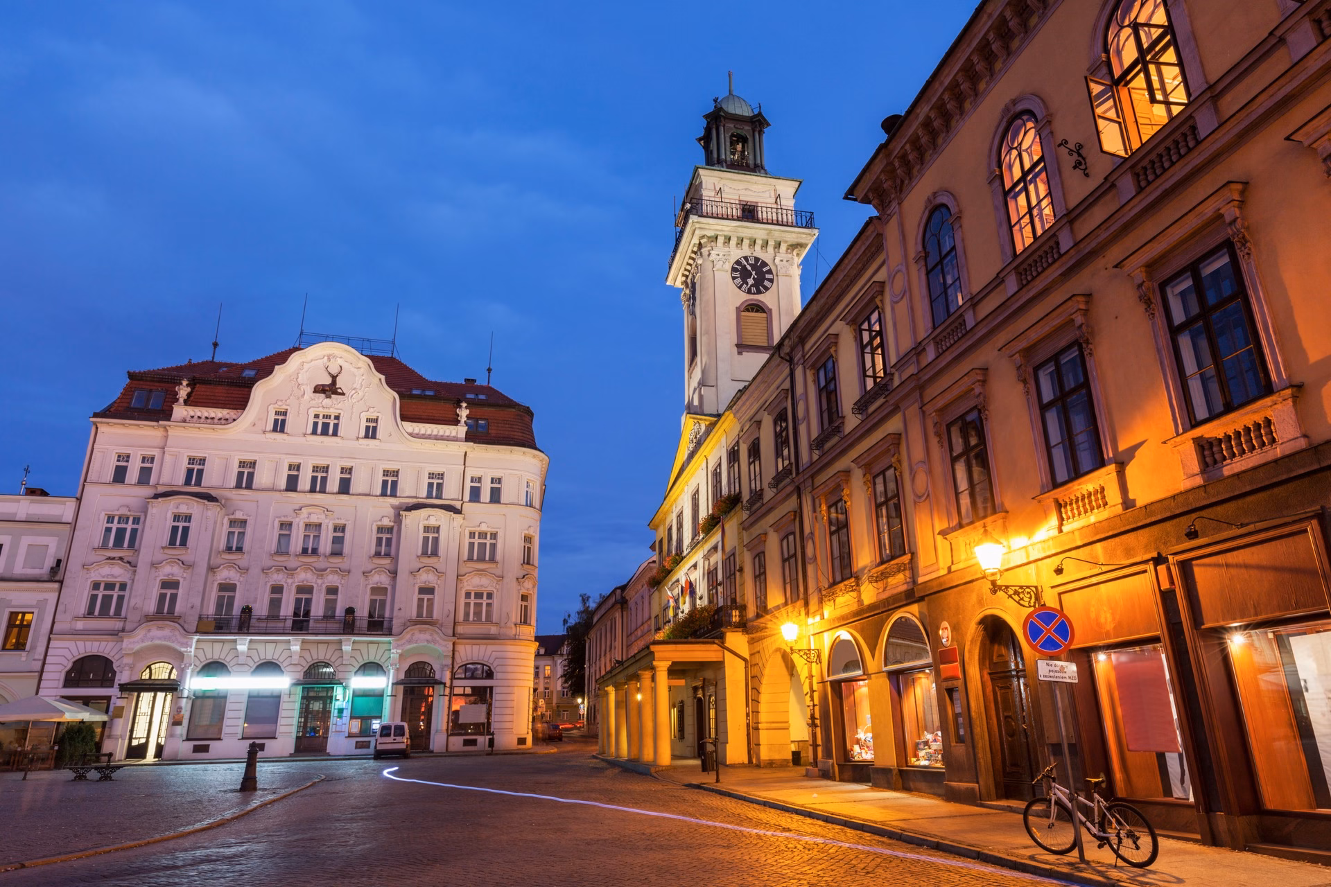 The Rynek in Cieszyn at dusk with the illuminated neoclassical town hall and fountain