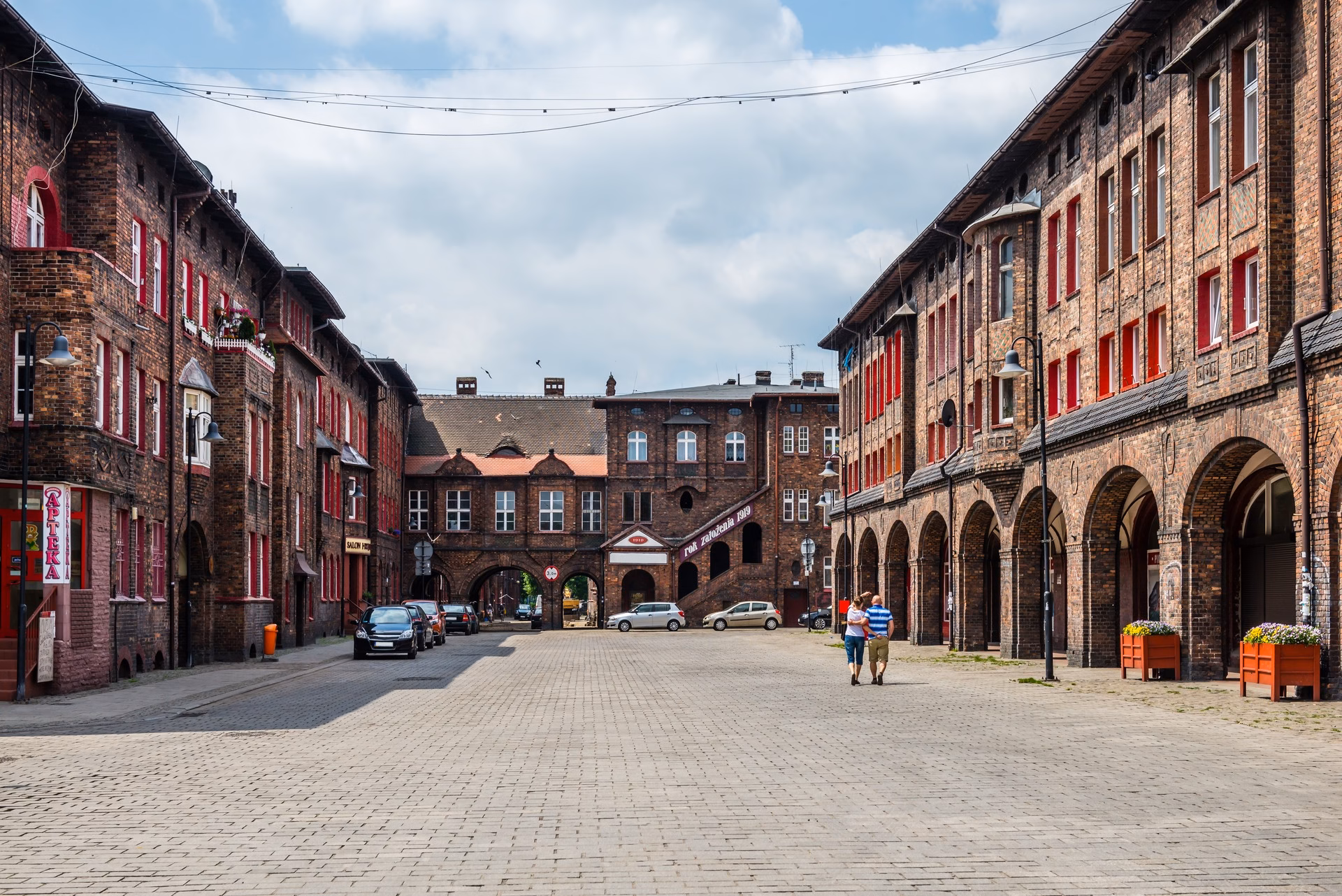 A street in Nikiszowiec with brick houses, arcades and a gateway passage