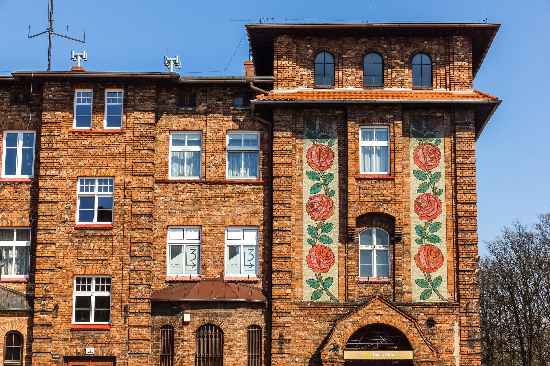 A brick house in Nikiszowiec with painted roses on the façade