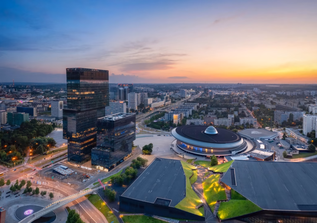 Katovice at dusk from a drone: Spodek hall, KTW skyscrapers and congress center with green roof